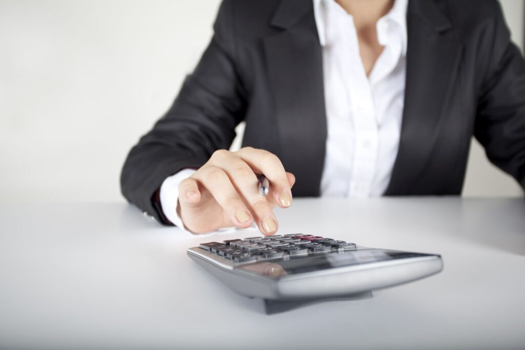 Woman wearing a suit using a calculator